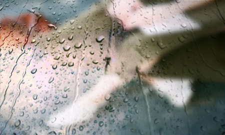 Background with rain drops close up. Rain drops on outdoor window, Closeup view transparent water drops on glass surface, humid water backdrop, blurred background with copy space for your textの写真素材