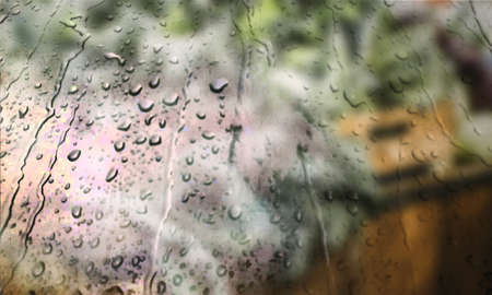 Background with rain drops close up. Rain drops on outdoor window, Closeup view transparent water drops on glass surface, humid water backdrop, blurred background with copy space for your textの写真素材