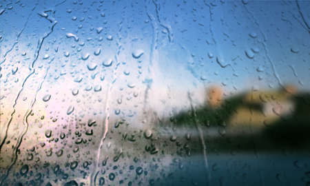 Background with rain drops close up. Rain drops on outdoor window, Closeup view transparent water drops on glass surface, humid water backdrop, blurred background with copy space for your textの写真素材