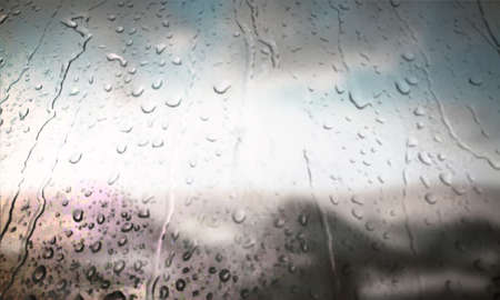 Background with rain drops close up. Rain drops on outdoor window, Closeup view transparent water drops on glass surface, humid water backdrop, blurred background with copy space for your textの写真素材