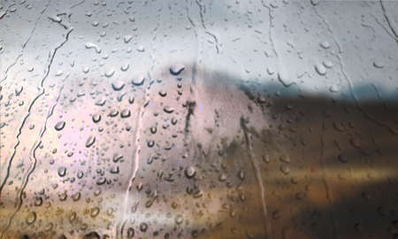 Background with rain drops close up. Rain drops on outdoor window, Closeup view transparent water drops on glass surface, humid water backdrop, blurred background with copy space for your textの写真素材