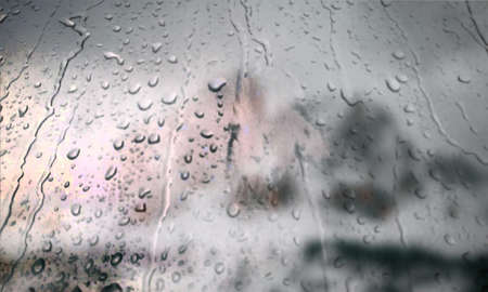 Background with rain drops close up. Rain drops on outdoor window, Closeup view transparent water drops on glass surface, humid water backdrop, blurred background with copy space for your textの写真素材