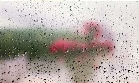 Background with rain drops close up. Rain drops on outdoor window, Closeup view transparent water drops on glass surface, humid water backdrop, blurred background with copy space for your textの写真素材