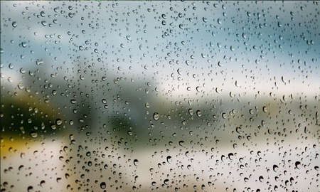 Background with rain drops close up. Rain drops on outdoor window, Closeup view transparent water drops on glass surface, humid water backdrop, blurred background with copy space for your textの写真素材
