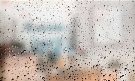 Background with rain drops close up. Rain drops on outdoor window, Closeup view transparent water drops on glass surface, humid water backdrop, blurred background with copy space for your textの写真素材