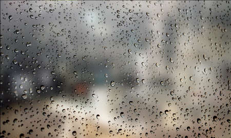 Background with rain drops close up. Rain drops on outdoor window, Closeup view transparent water drops on glass surface, humid water backdrop, blurred background with copy space for your textの写真素材