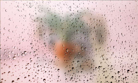 Background with rain drops close up. Rain drops on outdoor window, Closeup view transparent water drops on glass surface, humid water backdrop, blurred background with copy space for your textの写真素材
