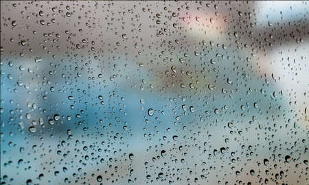 Background with rain drops close up. Rain drops on outdoor window, Closeup view transparent water drops on glass surface, humid water backdrop, blurred background with copy space for your textの写真素材