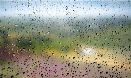 Background with rain drops close up. Rain drops on outdoor window, Closeup view transparent water drops on glass surface, humid water backdrop, blurred background with copy space for your textの写真素材