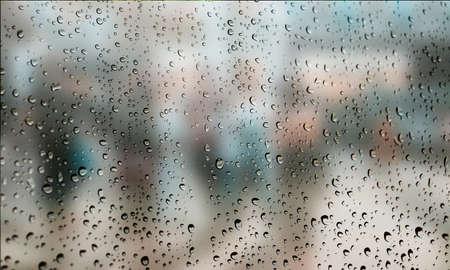 Background with rain drops close up. Rain drops on outdoor window, Closeup view transparent water drops on glass surface, humid water backdrop, blurred background with copy space for your textの写真素材