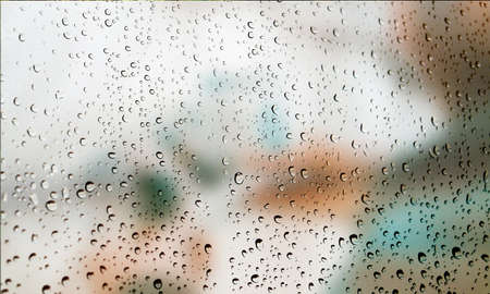 Background with rain drops close up. Rain drops on outdoor window, Closeup view transparent water drops on glass surface, humid water backdrop, blurred background with copy space for your textの写真素材