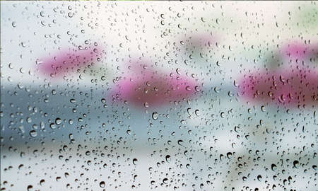 Background with rain drops close up. Rain drops on outdoor window, Closeup view transparent water drops on glass surface, humid water backdrop, blurred background with copy space for your textの写真素材