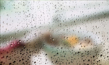 Background with rain drops close up. Rain drops on outdoor window, Closeup view transparent water drops on glass surface, humid water backdrop, blurred background with copy space for your textの写真素材