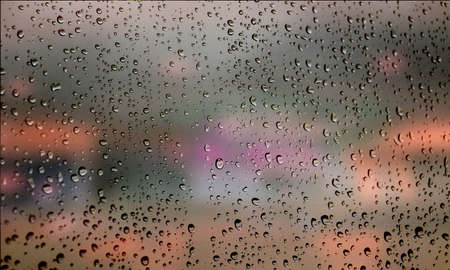 Background with rain drops close up. Rain drops on outdoor window, Closeup view transparent water drops on glass surface, humid water backdrop, blurred background with copy space for your textの写真素材