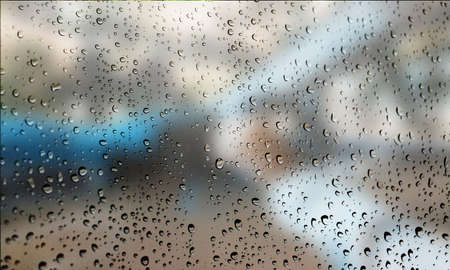 Background with rain drops close up. Rain drops on outdoor window, Closeup view transparent water drops on glass surface, humid water backdrop, blurred background with copy space for your textの写真素材