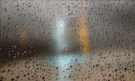 Background with rain drops close up. Rain drops on outdoor window, Closeup view transparent water drops on glass surface, humid water backdrop, blurred background with copy space for your textの写真素材