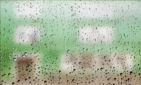 Background with rain drops close up. Rain drops on outdoor window, Closeup view transparent water drops on glass surface, humid water backdrop, blurred background with copy space for your textの写真素材