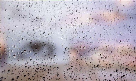 Background with rain drops close up. Rain drops on outdoor window, Closeup view transparent water drops on glass surface, humid water backdrop, blurred background with copy space for your textの写真素材