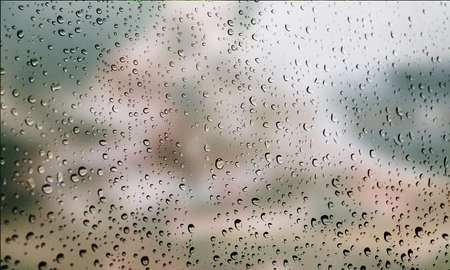 Background with rain drops close up. Rain drops on outdoor window, Closeup view transparent water drops on glass surface, humid water backdrop, blurred background with copy space for your textの写真素材
