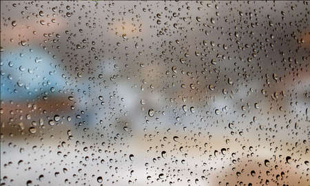Background with rain drops close up. Rain drops on outdoor window, Closeup view transparent water drops on glass surface, humid water backdrop, blurred background with copy space for your textの写真素材