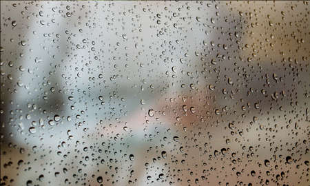 Background with rain drops close up. Rain drops on outdoor window, Closeup view transparent water drops on glass surface, humid water backdrop, blurred background with copy space for your textの写真素材