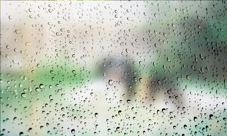 Background with rain drops close up. Rain drops on outdoor window, Closeup view transparent water drops on glass surface, humid water backdrop, blurred background with copy space for your textの写真素材