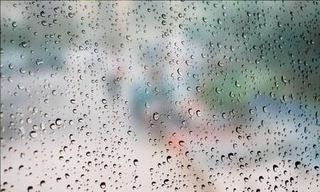 Background with rain drops close up. Rain drops on outdoor window, Closeup view transparent water drops on glass surface, humid water backdrop, blurred background with copy space for your textの写真素材