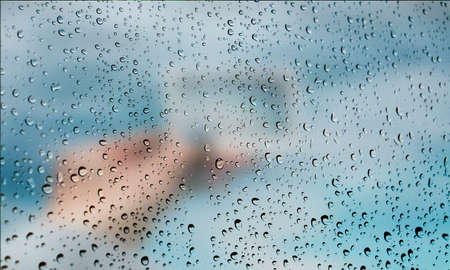 Background with rain drops close up. Rain drops on outdoor window, Closeup view transparent water drops on glass surface, humid water backdrop, blurred background with copy space for your textの写真素材