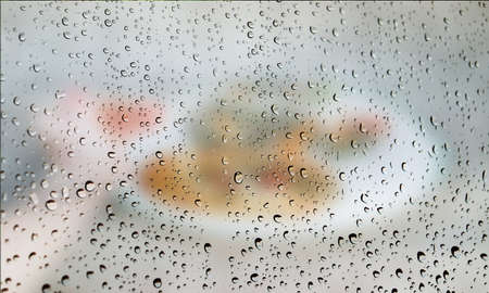 Background with rain drops close up. Rain drops on outdoor window, Closeup view transparent water drops on glass surface, humid water backdrop, blurred background with copy space for your textの写真素材