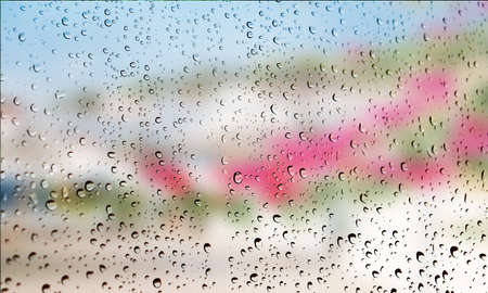 Background with rain drops close up. Rain drops on outdoor window, Closeup view transparent water drops on glass surface, humid water backdrop, blurred background with copy space for your textの写真素材
