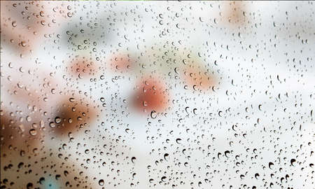 Background with rain drops close up. Rain drops on outdoor window, Closeup view transparent water drops on glass surface, humid water backdrop, blurred background with copy space for your textの写真素材