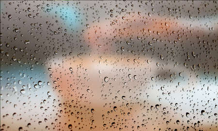 Background with rain drops close up. Rain drops on outdoor window, Closeup view transparent water drops on glass surface, humid water backdrop, blurred background with copy space for your textの写真素材