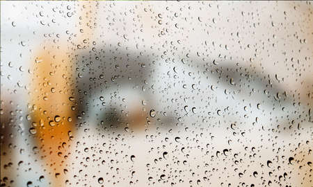 Background with rain drops close up. Rain drops on outdoor window, Closeup view transparent water drops on glass surface, humid water backdrop, blurred background with copy space for your textの写真素材