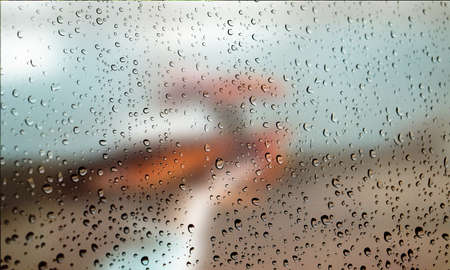 Background with rain drops close up. Rain drops on outdoor window, Closeup view transparent water drops on glass surface, humid water backdrop, blurred background with copy space for your textの写真素材
