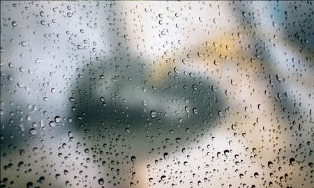 Background with rain drops close up. Rain drops on outdoor window, Closeup view transparent water drops on glass surface, humid water backdrop, blurred background with copy space for your textの写真素材