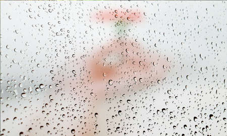 Background with rain drops close up. Rain drops on outdoor window, Closeup view transparent water drops on glass surface, humid water backdrop, blurred background with copy space for your textの写真素材