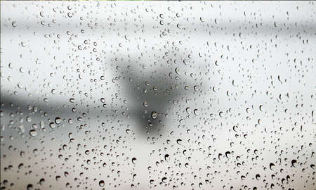 Background with rain drops close up. Rain drops on outdoor window, Closeup view transparent water drops on glass surface, humid water backdrop, blurred background with copy space for your textの写真素材