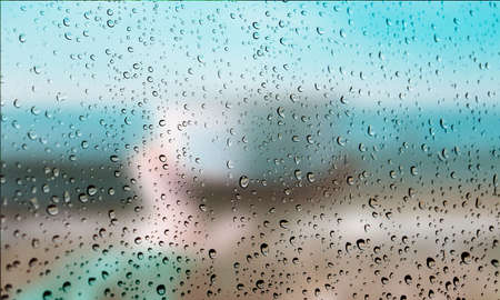 Background with rain drops close up. Rain drops on outdoor window, Closeup view transparent water drops on glass surface, humid water backdrop, blurred background with copy space for your textの写真素材