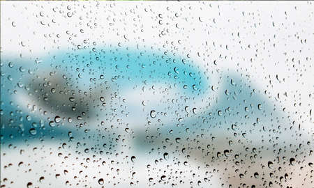 Background with rain drops close up. Rain drops on outdoor window, Closeup view transparent water drops on glass surface, humid water backdrop, blurred background with copy space for your textの写真素材