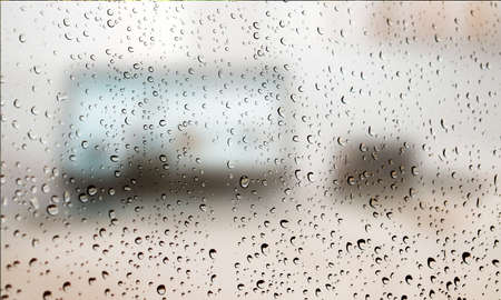 Background with rain drops close up. Rain drops on outdoor window, Closeup view transparent water drops on glass surface, humid water backdrop, blurred background with copy space for your textの写真素材