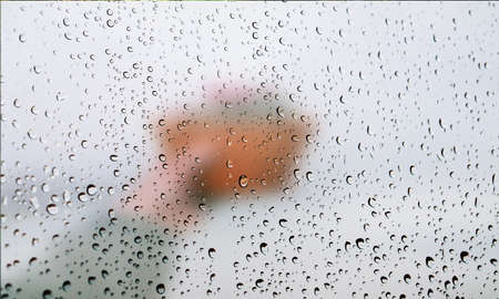 Background with rain drops close up. Rain drops on outdoor window, Closeup view transparent water drops on glass surface, humid water backdrop, blurred background with copy space for your textの写真素材