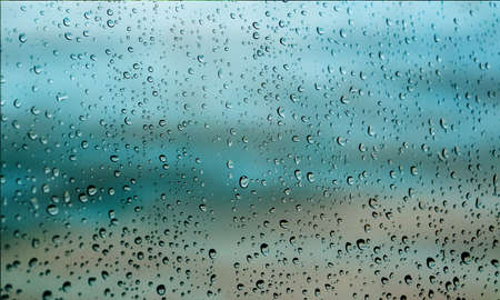 Background with rain drops close up. Rain drops on outdoor window, Closeup view transparent water drops on glass surface, humid water backdrop, blurred background with copy space for your textの写真素材