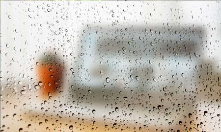 Background with rain drops close up. Rain drops on outdoor window, Closeup view transparent water drops on glass surface, humid water backdrop, blurred background with copy space for your textの写真素材