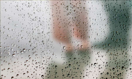 Background with rain drops close up. Rain drops on outdoor window, Closeup view transparent water drops on glass surface, humid water backdrop, blurred background with copy space for your textの写真素材