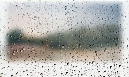 Background with rain drops close up. Rain drops on outdoor window, Closeup view transparent water drops on glass surface, humid water backdrop, blurred background with copy space for your textの写真素材