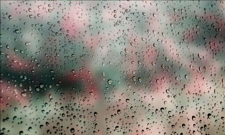 Background with rain drops close up. Rain drops on outdoor window, Closeup view transparent water drops on glass surface, humid water backdrop, blurred background with copy space for your textの写真素材