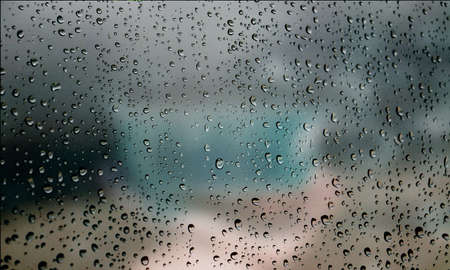 Background with rain drops close up. Rain drops on outdoor window, Closeup view transparent water drops on glass surface, humid water backdrop, blurred background with copy space for your textの写真素材