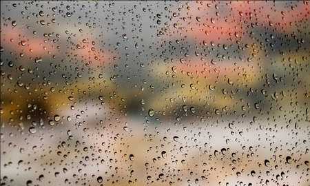 Background with rain drops close up. Rain drops on outdoor window, Closeup view transparent water drops on glass surface, humid water backdrop, blurred background with copy space for your textの写真素材