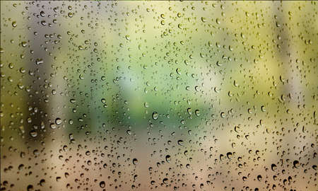 Background with rain drops close up. Rain drops on outdoor window, Closeup view transparent water drops on glass surface, humid water backdrop, blurred background with copy space for your textの写真素材