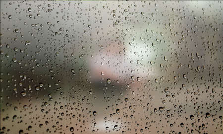 Background with rain drops close up. Rain drops on outdoor window, Closeup view transparent water drops on glass surface, humid water backdrop, blurred background with copy space for your textの写真素材